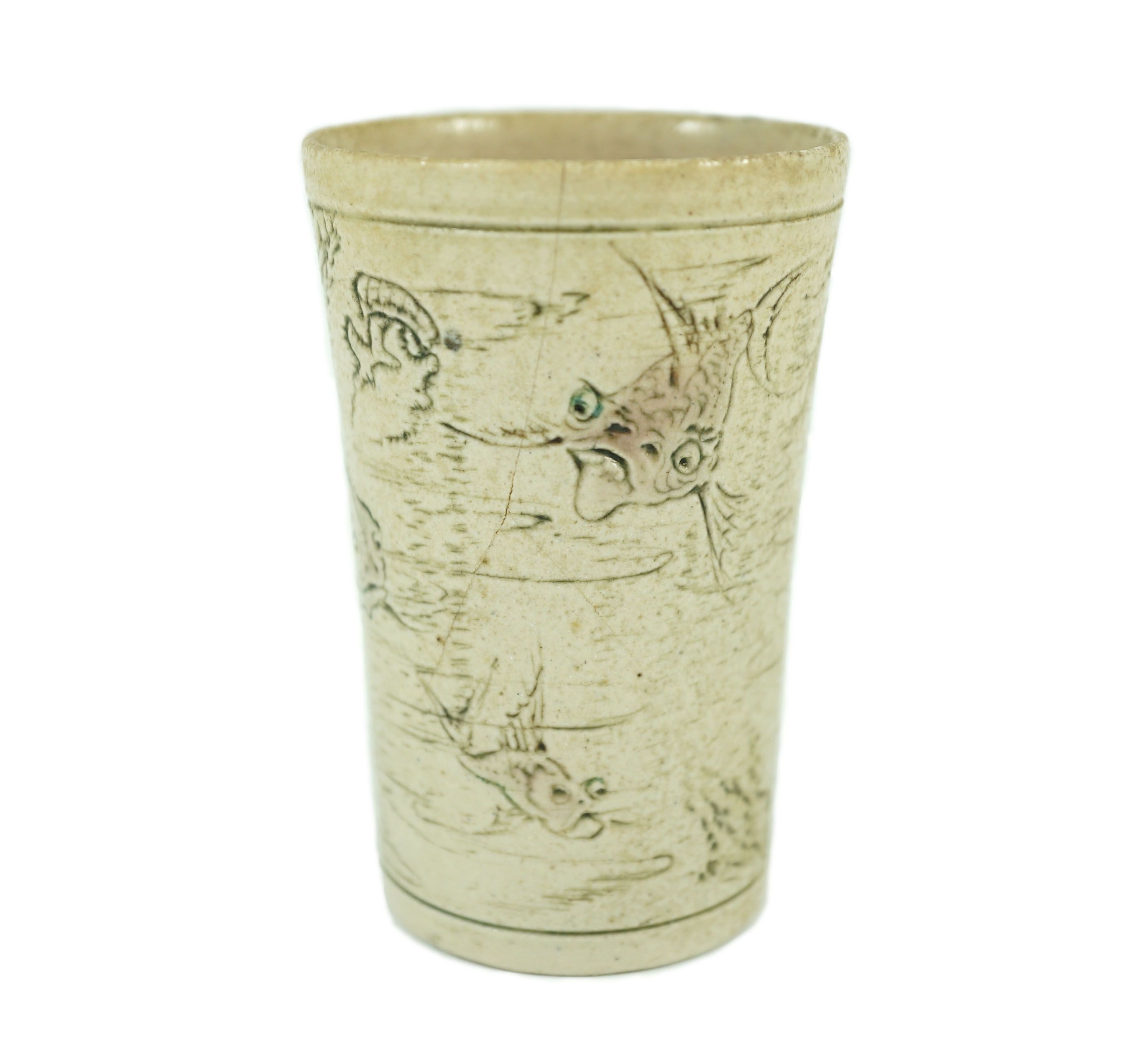 A Martin Brothers ‘grotesque fish’ beaker, dated 1914, 8.7cm high, hairline crack